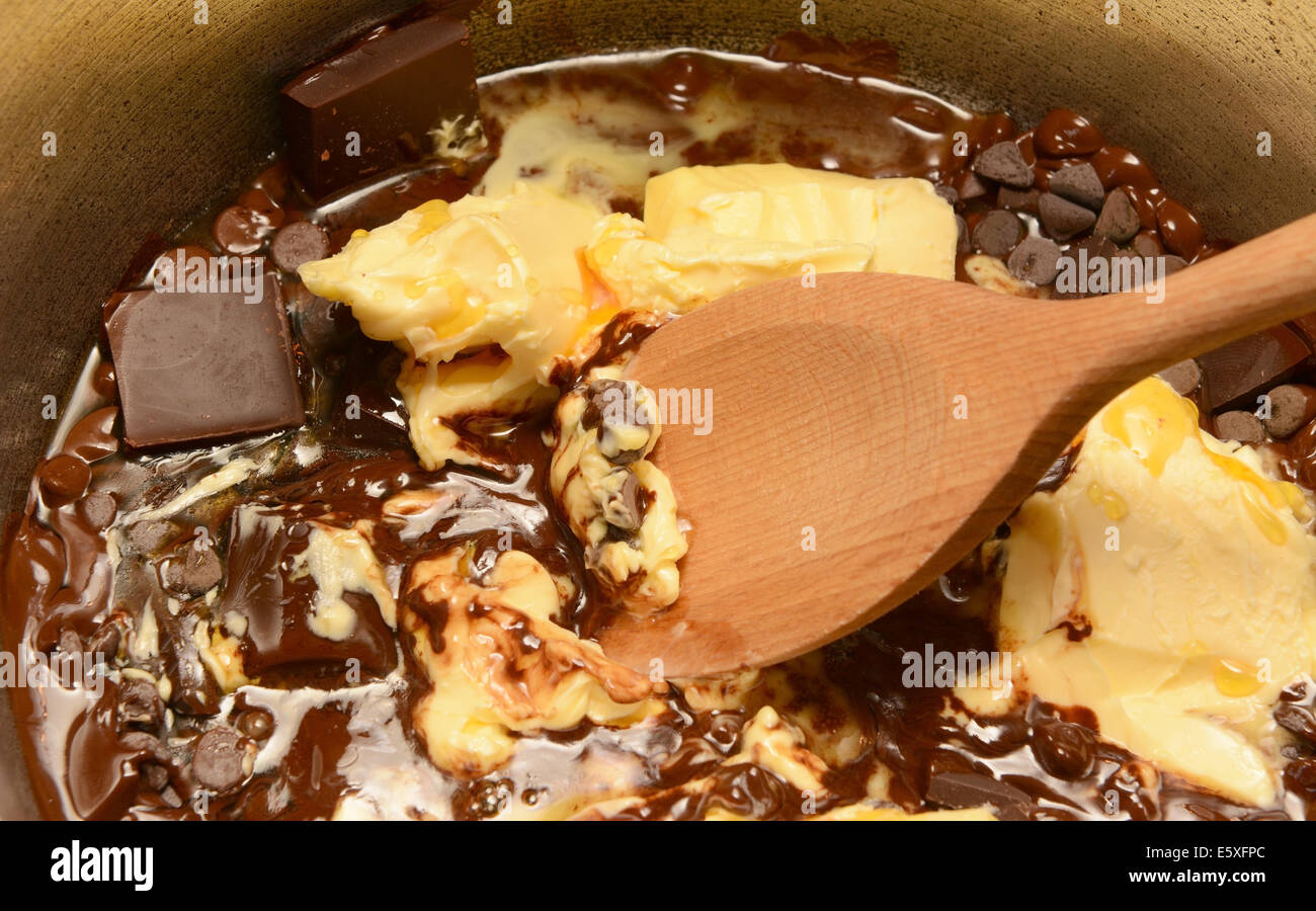 Faire fondre le beurre et le chocolat noir dans une casserole, en remuant avec une cuillère en bois Banque D'Images