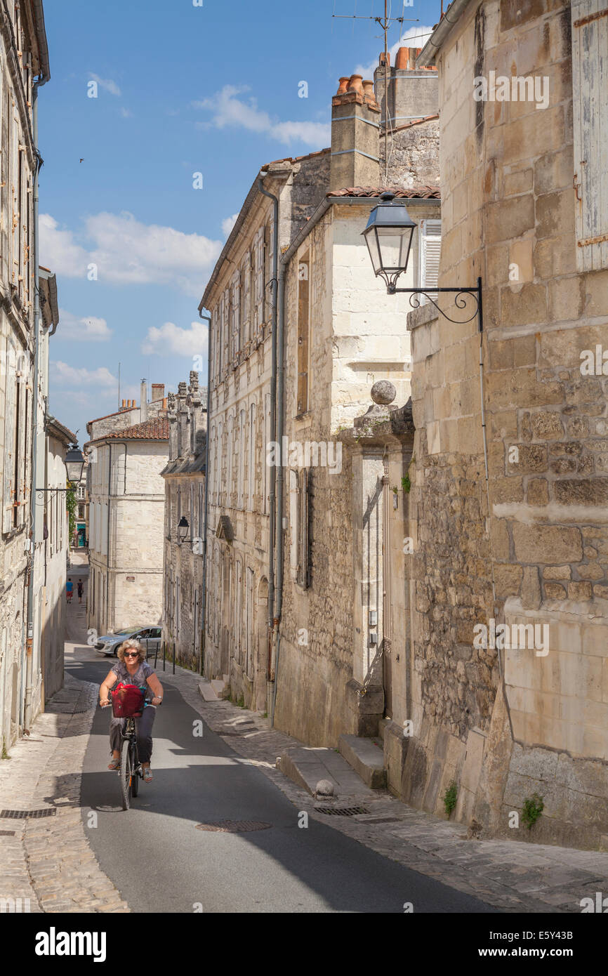 Vélo femme la colline raide de la rue des Jacobins à Saintes Banque D'Images