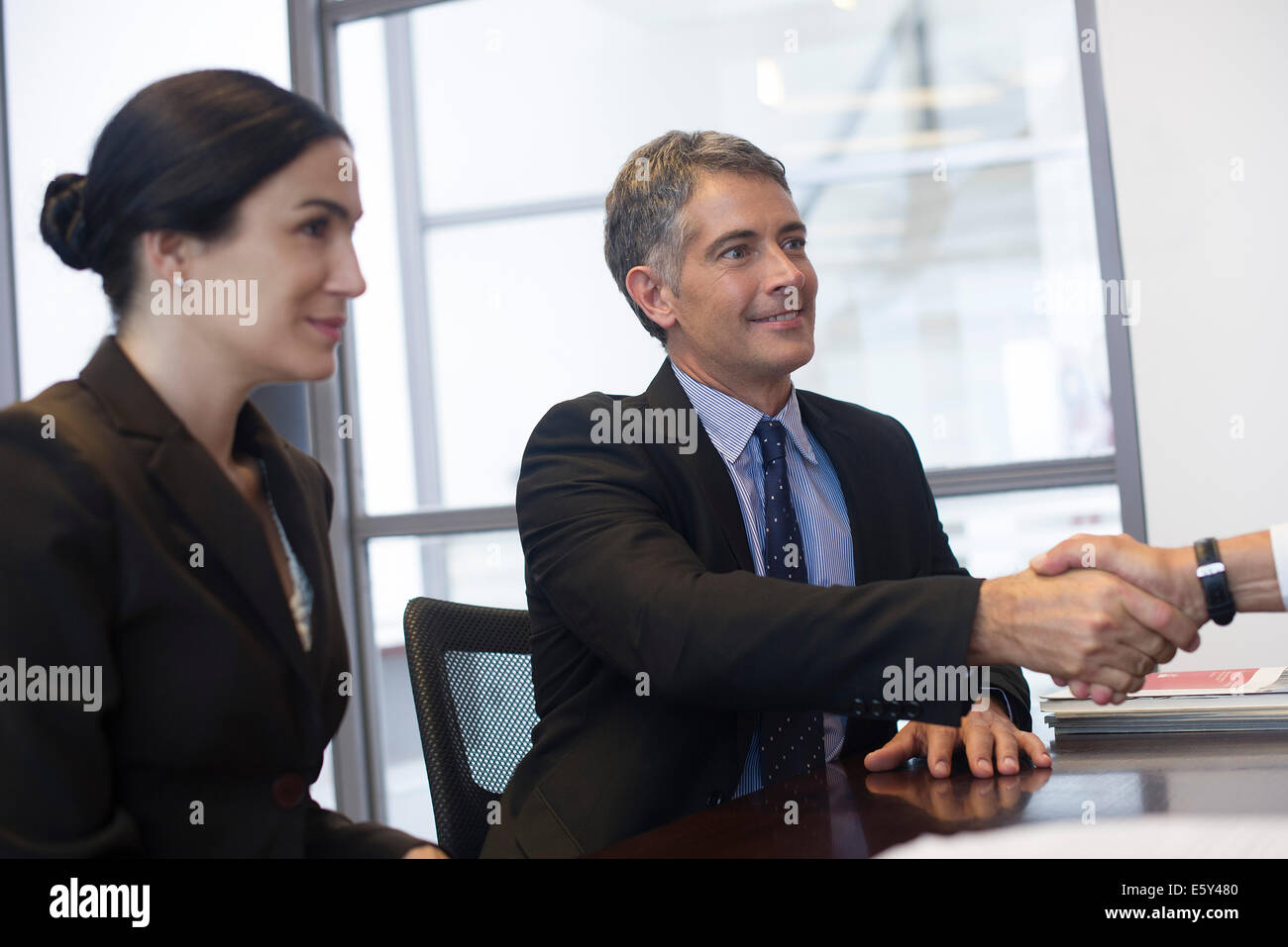 Réunion d'affaire, businessman shaking hands with out-of-frame associer Banque D'Images