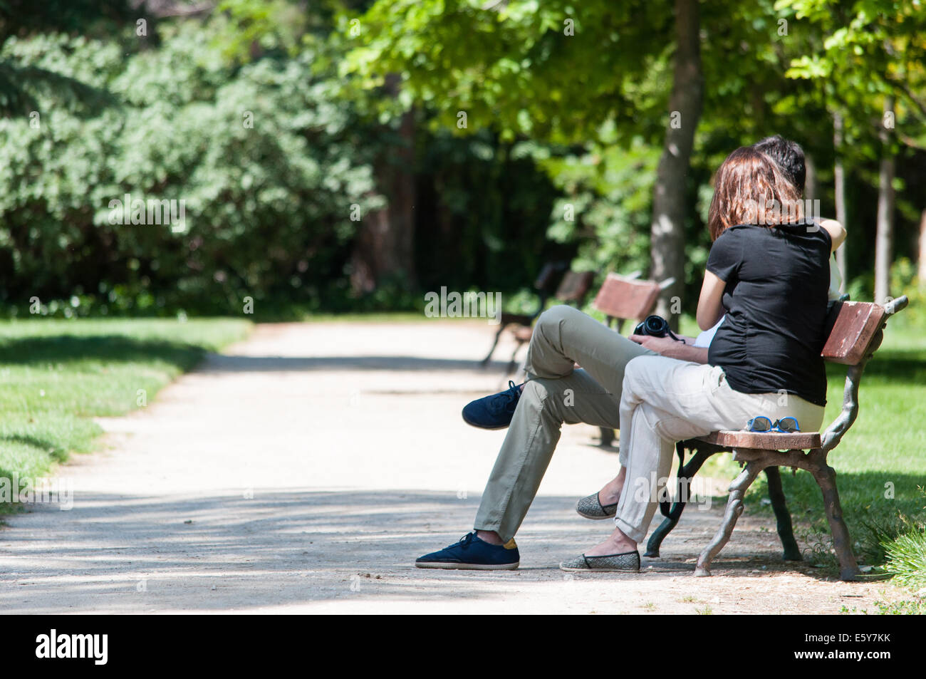 Couple assis sur un banc au soleil Banque D'Images