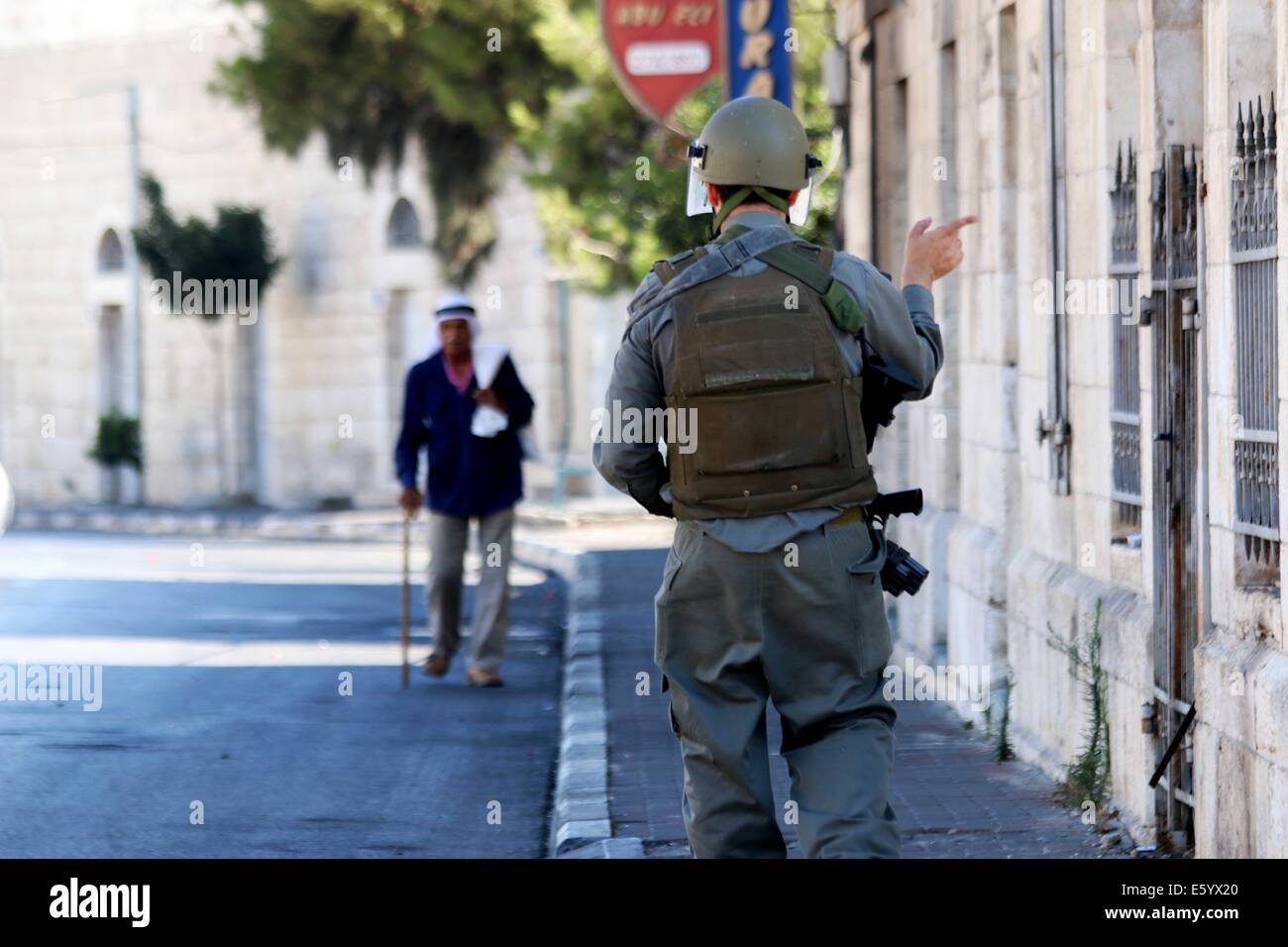 Un vieux palestinien se dirige vers les soldats israéliens qui ont fermé les rues de Bethléem comme protestataires d'affrontements avec des soldats. Le soldat israélien a crié au vieil homme pour revenir en arrière, mais l'homme a soutenu avec lui pendant un certain temps lui disant qu'il avait rendez-vous utiliser cette rue pour rentrer à la maison. Vendredi après-midi a été déclarée une rage à travers la Cisjordanie. Plus tôt ce matin, après 8 A.m., le cessez-le-feu de 72 heures entre Gaza et Israël a pris fin et les combats ont repris. En début de soirée, les forces israéliennes ont tué Ahmad Mohammad al-Qatari de camp de réfugiés d'Al Amari près de Ramallah, alors que les manifestations ont continué à l'état solide Banque D'Images