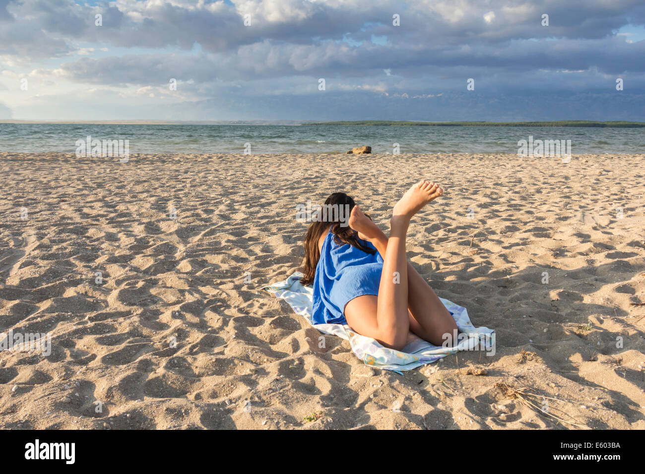 Vue arrière du jolie fille allongée sur une plage de sable sur l'été