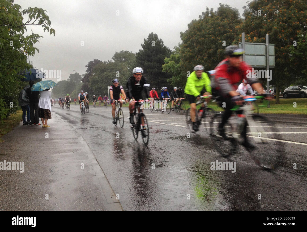 West Molesey, Surrey, UK. 10e Août, 2014. Les cyclistes dans le Prudential Ride London font face à une pluie torrentielle comme ils passent par West Molesey, Surrey. Credit : Céphas Photo Library/Alamy Live News Banque D'Images
