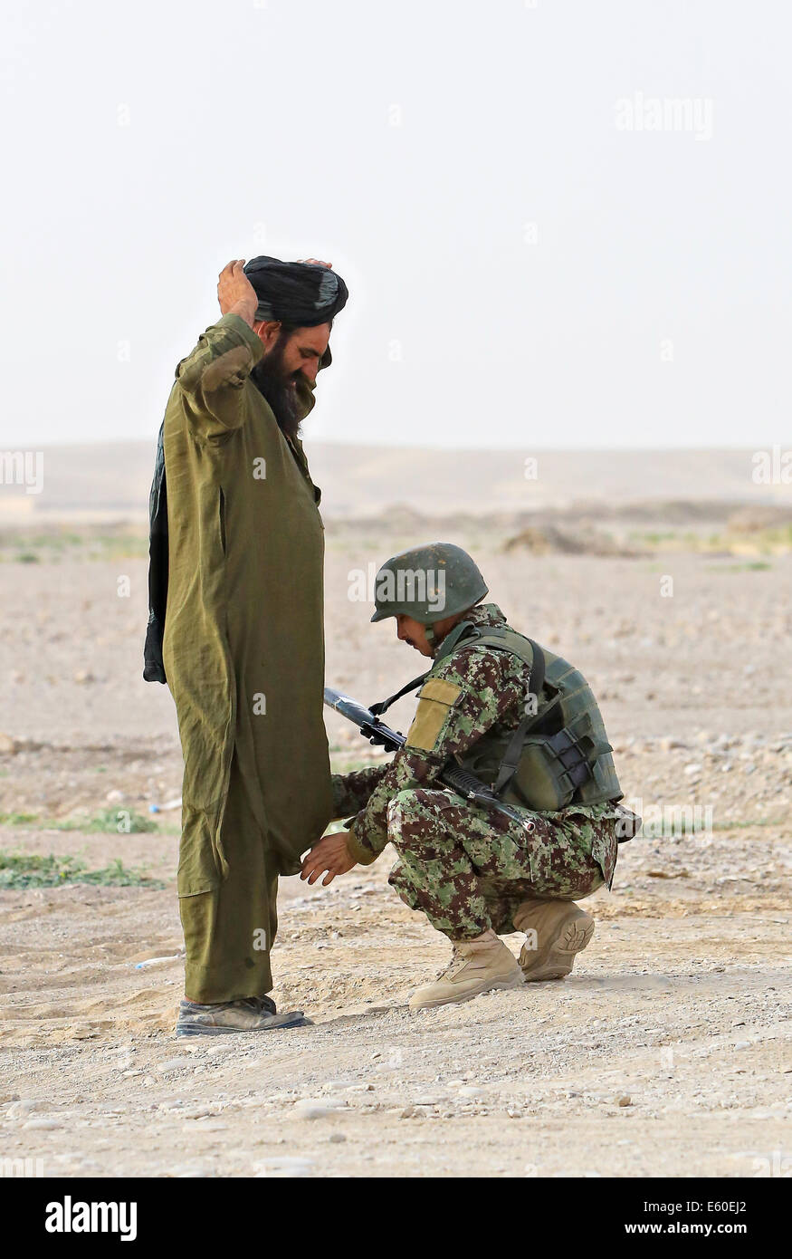 Un Afghan est recherché par un soldat de l'Armée nationale afghane à un poste de contrôle des véhicules, 14 juillet 2014 dans le village Shekasteh Tappeh, province de Helmand, Afghanistan, le 14 juillet 2014. Banque D'Images