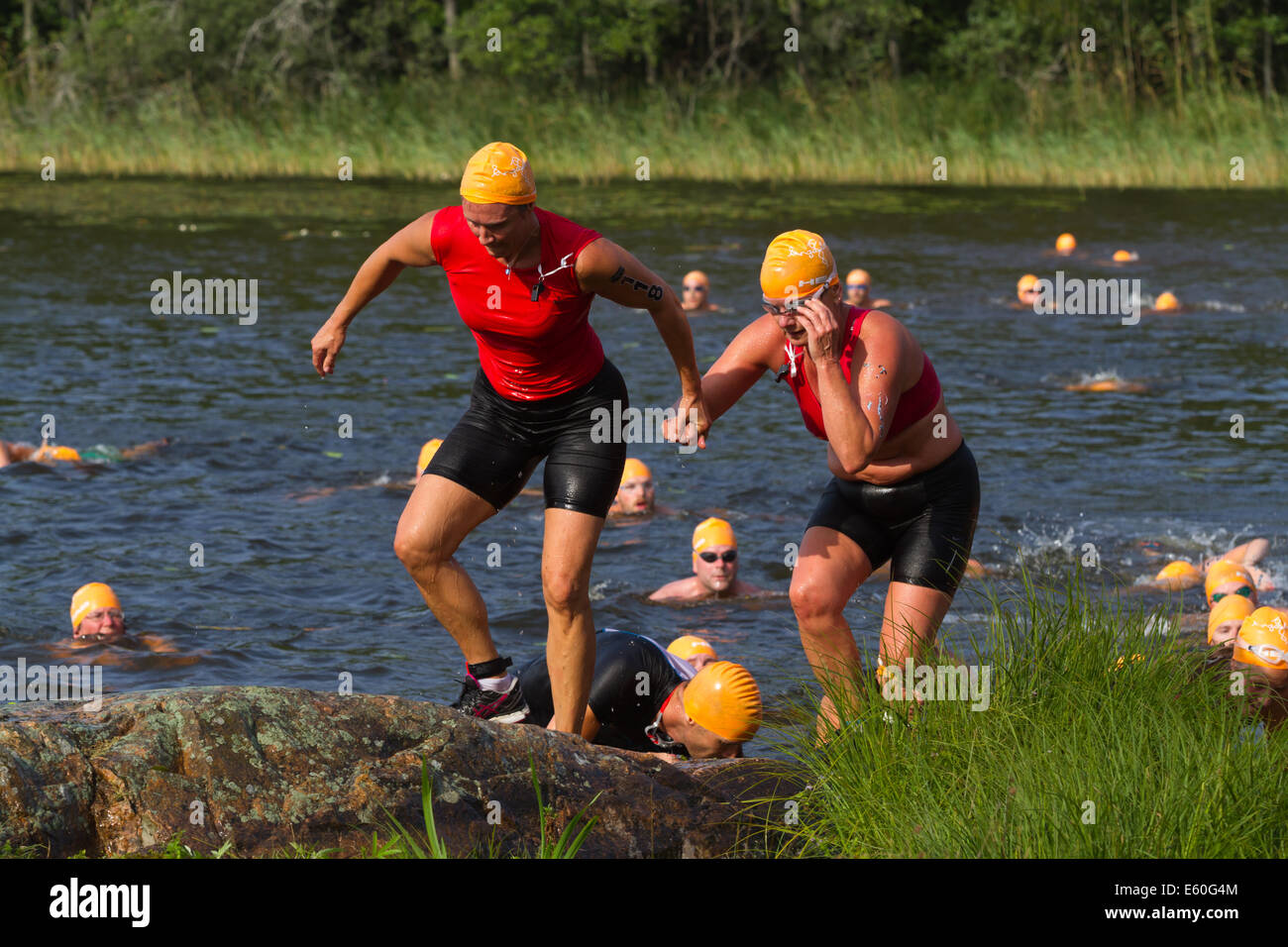 Les gens participant à un swimrun Ångaloppet, compétition où vous exécutez sur terre et se baigner dans les lacs et la mer à plusieurs reprises. Banque D'Images