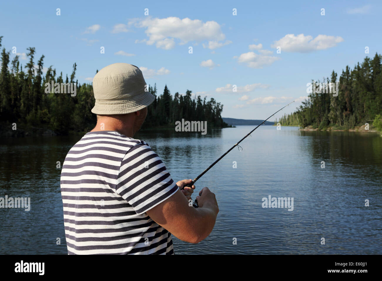 Un homme à la pêche près de Missinipe Otter Lake, Saskatchewan, Canada. Banque D'Images