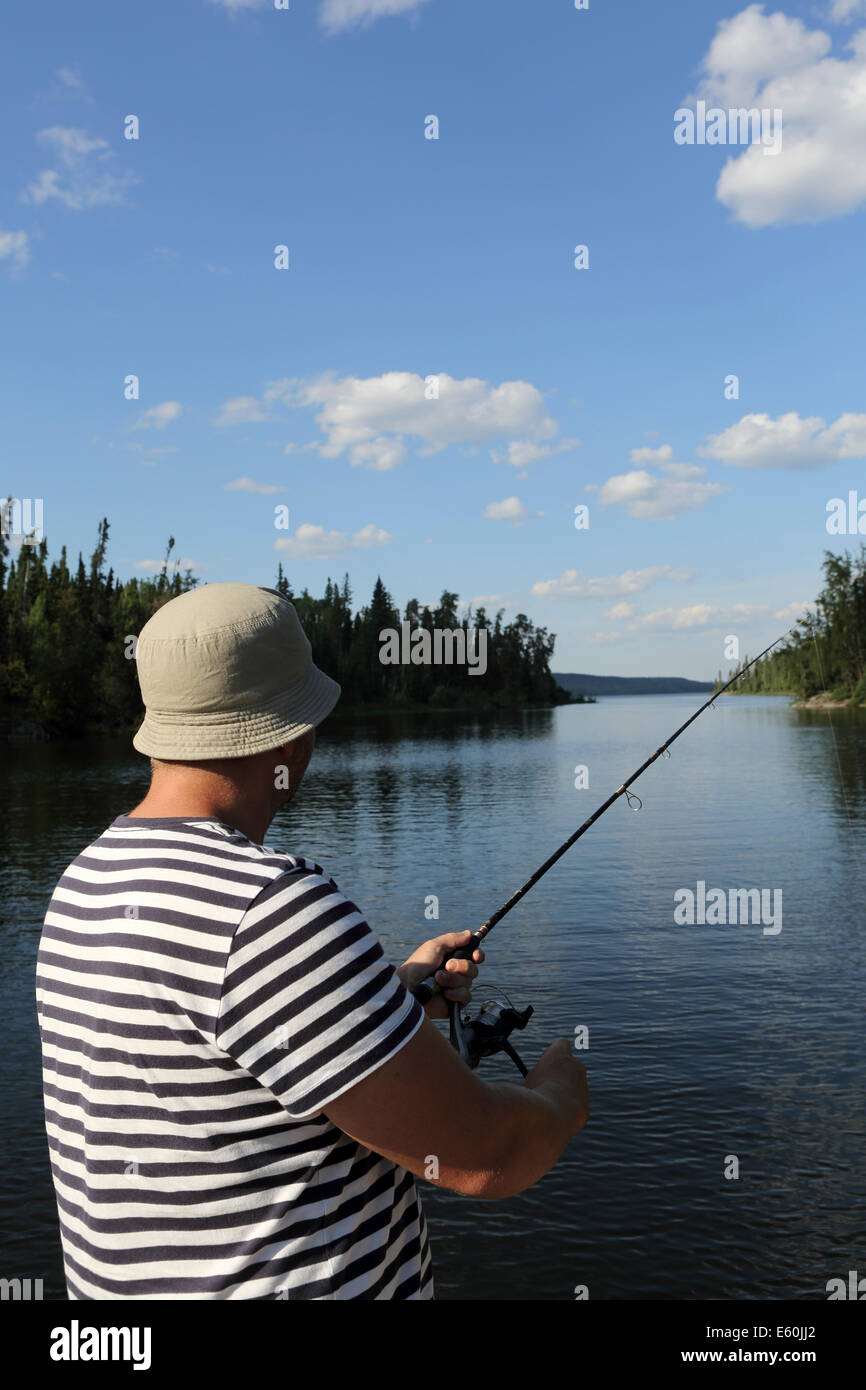 Un homme à la pêche près de Missinipe Otter Lake, Saskatchewan, Canada. Banque D'Images