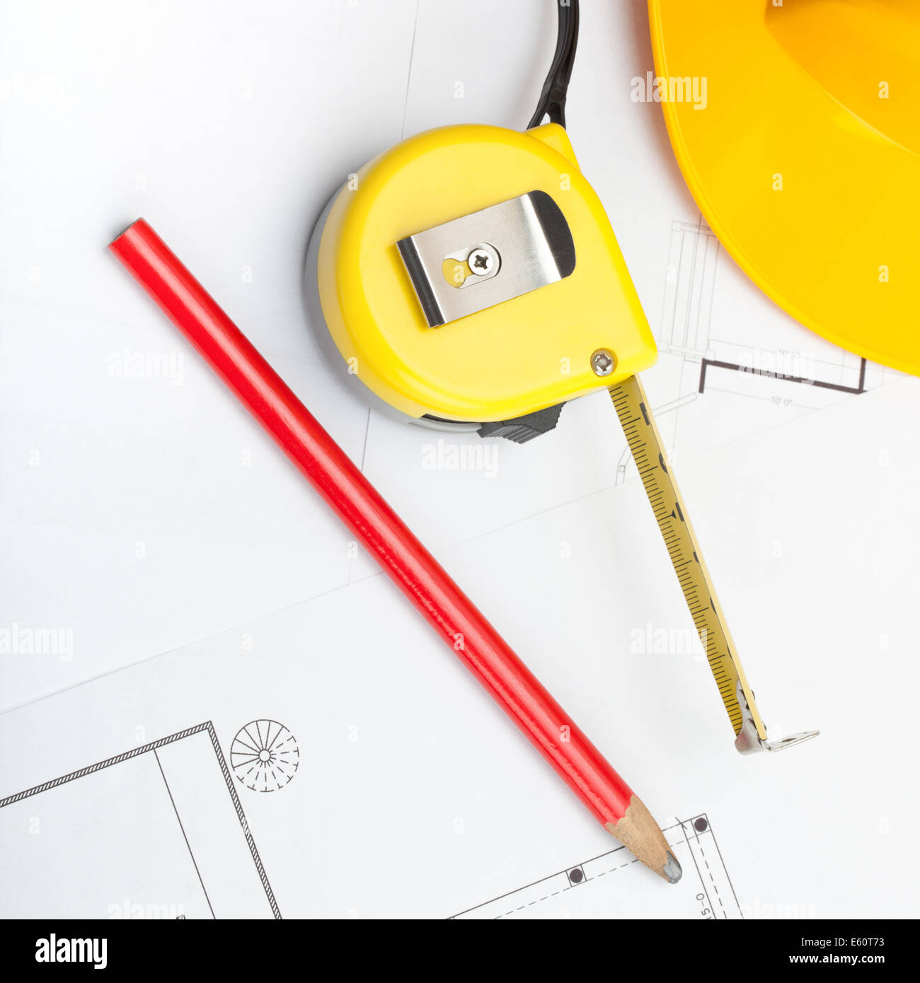 Construction jaune casque avec crayon et mesurer ruban sur certains documents - 1 à 1 Banque D'Images