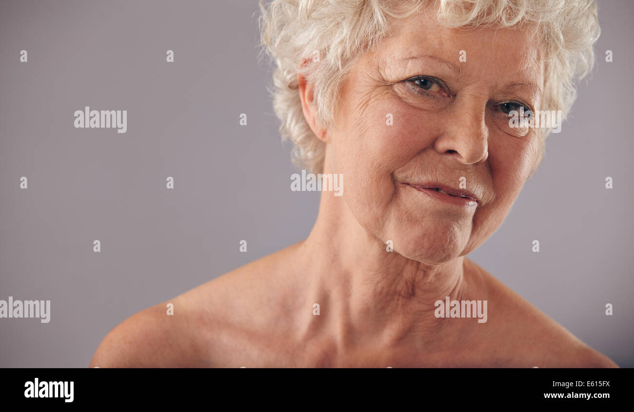 Close-up portrait de femmes de race blanche de face contre un arrière-plan gris. La peau froissée avec Senior woman looking at camera. Banque D'Images