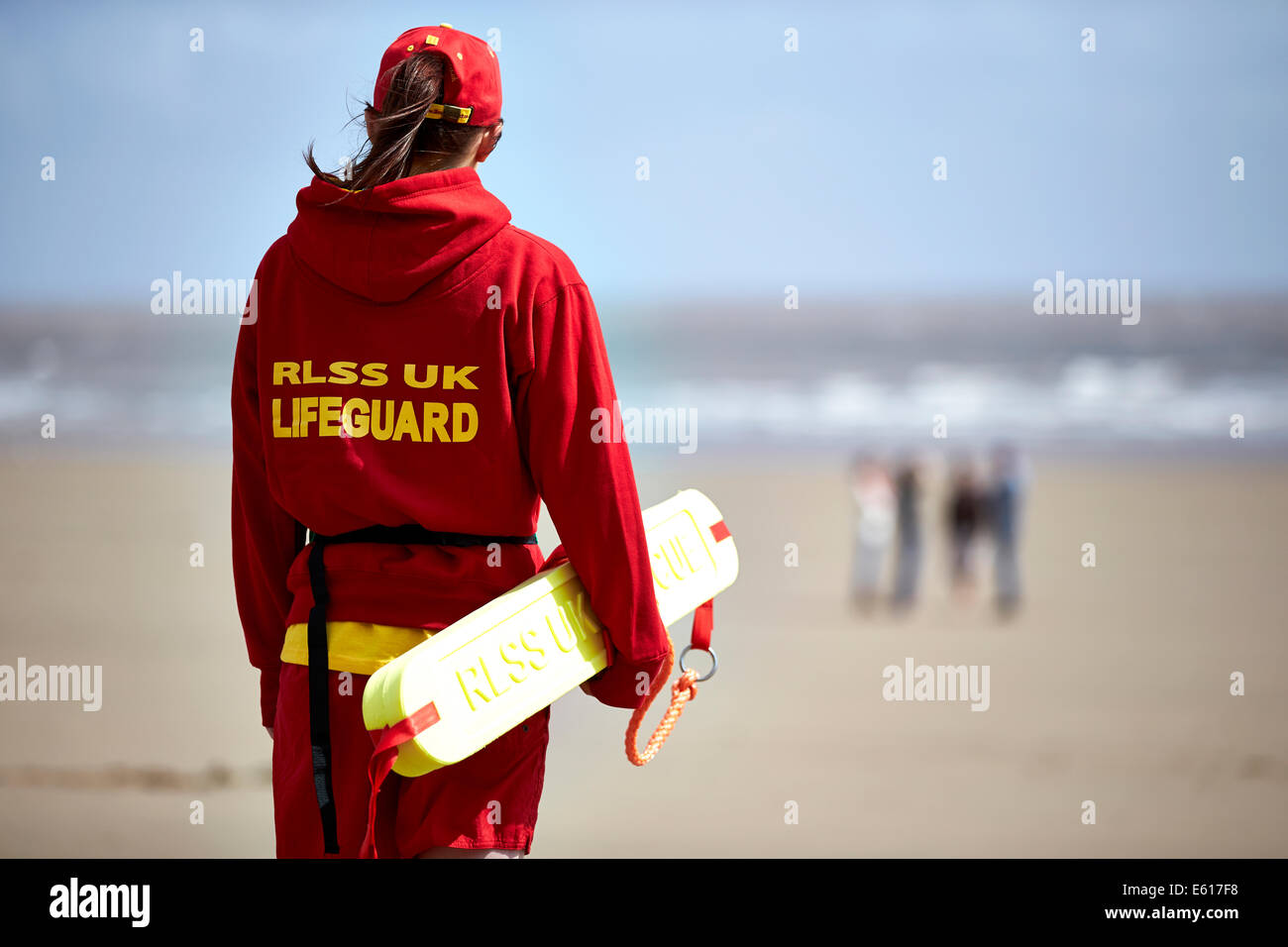 Un RLSS ou Royal Life Saving life guard monte la garde près de la mer sur une plage. Les gardiens de la vie aident à prévenir la noyade dans l'eau. Banque D'Images
