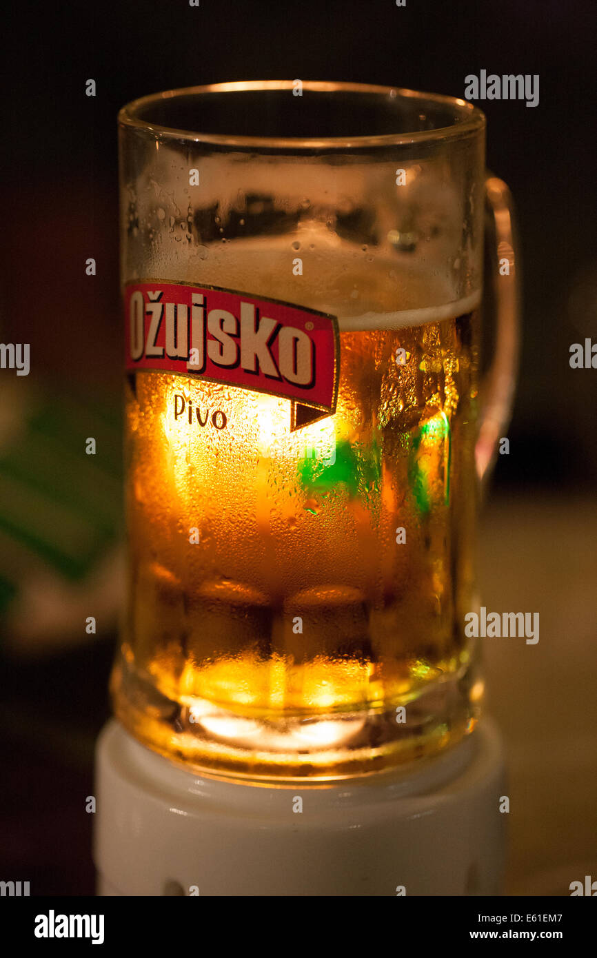 Un verre de bière croate tankard orange avec la condensation sur le côté et un éclairage subtil à travers le verre Banque D'Images