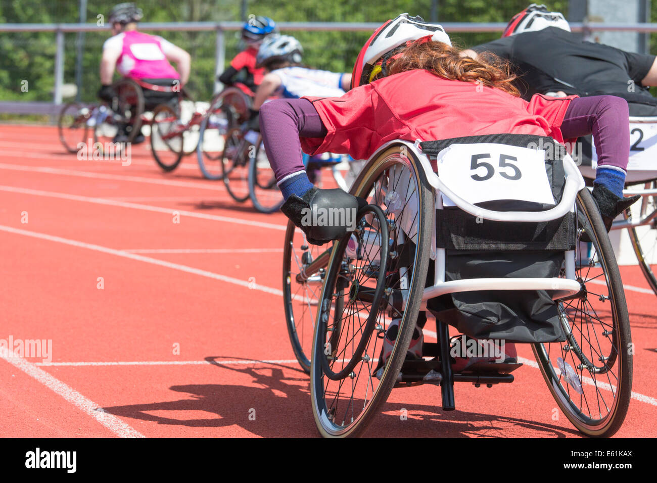 Les athlètes à une course en fauteuil roulant dans un stade Banque D'Images