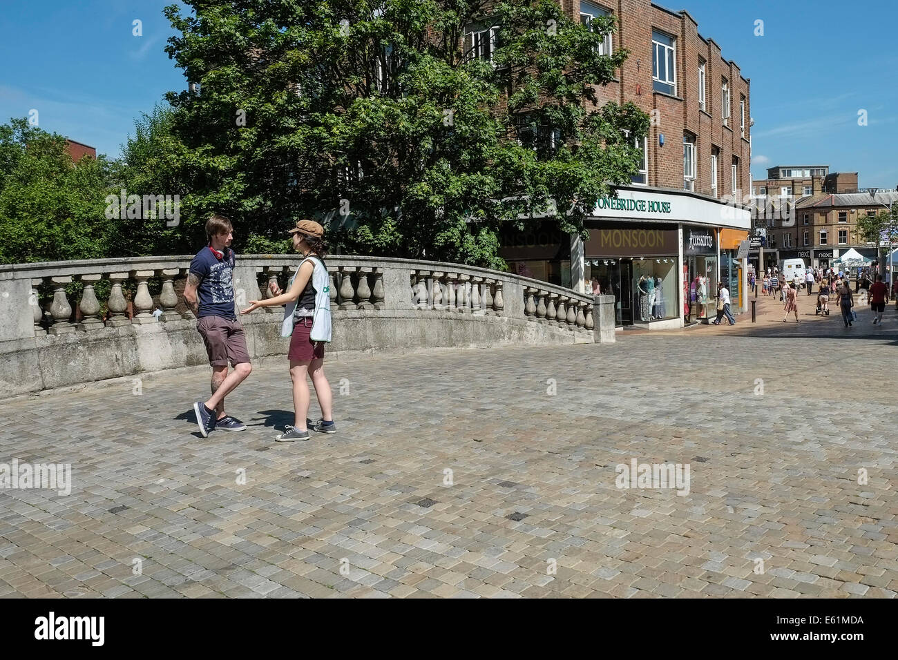 Deux personnes en conversation sur le pont de pierre dans le centre-ville de Chelmsford. Banque D'Images