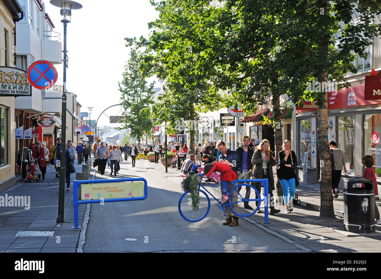Les gens, les magasins, restaurants et pubs à pied du côté de la rue Laugavegur, dans le centre de Reykjavik sur une journée ensoleillée en Islande Banque D'Images
