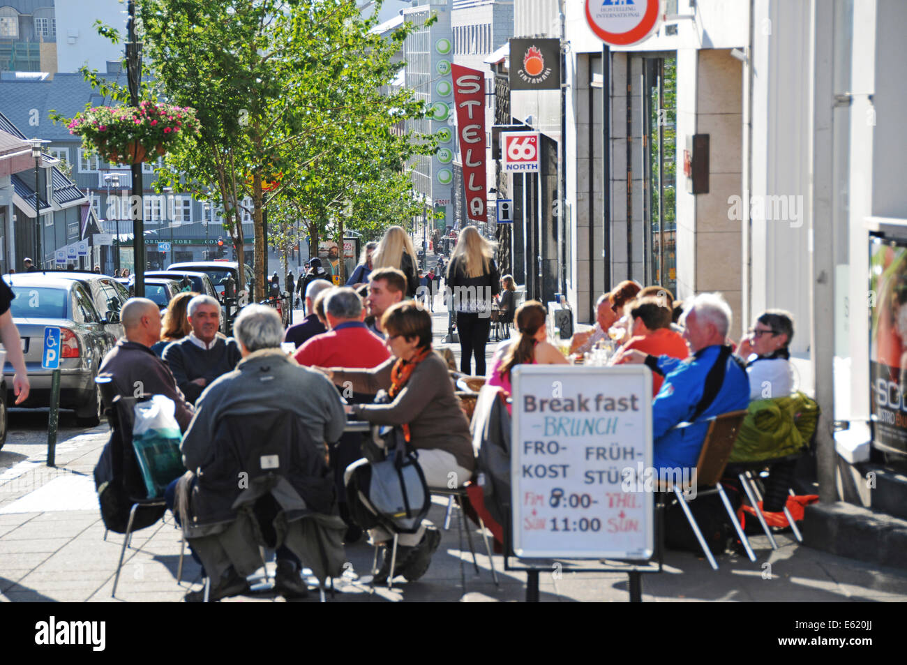 Les gens, les magasins, restaurants et pubs à pied du côté de la rue Laugavegur, dans le centre de Reykjavik sur une journée ensoleillée en Islande Banque D'Images