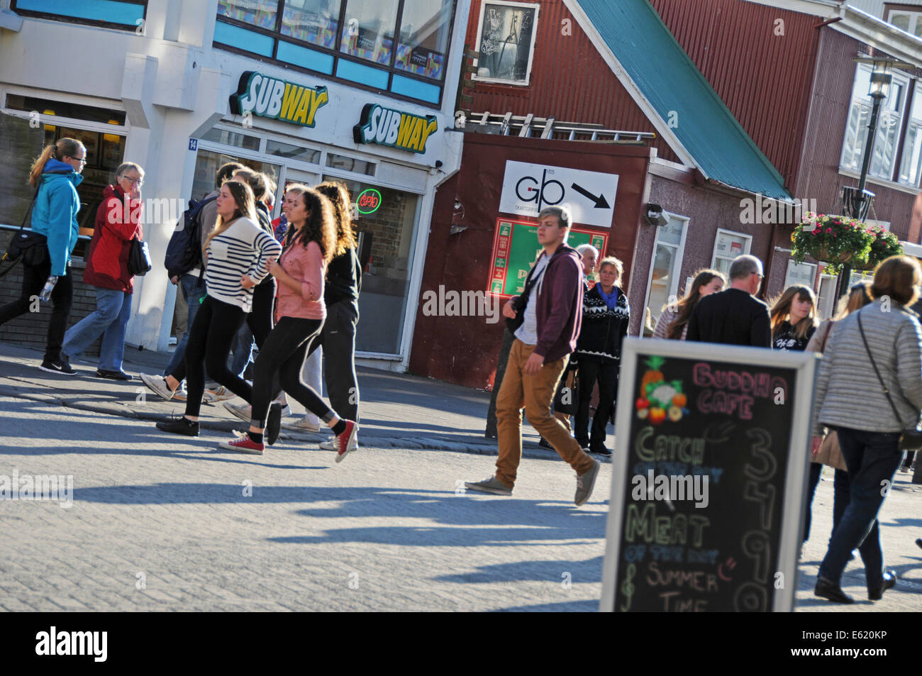 Les gens, les magasins, restaurants et pubs à pied du côté de la rue Laugavegur, dans le centre de Reykjavik sur une journée ensoleillée en Islande Banque D'Images