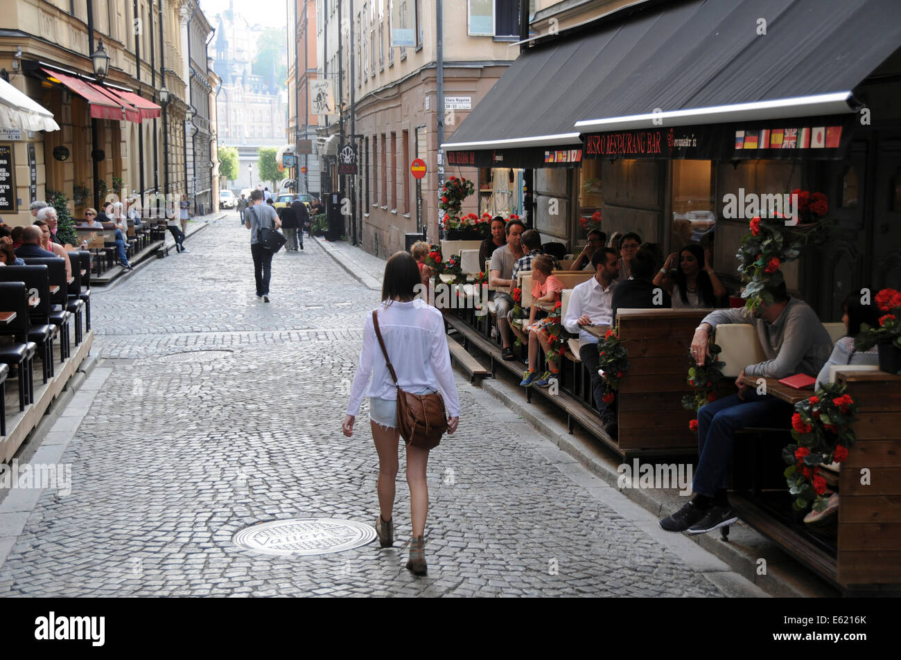 Street life in old Stockholm avec restaurants, cafés de trottoir, les piétons et les musiciens le long de rues pavées Banque D'Images