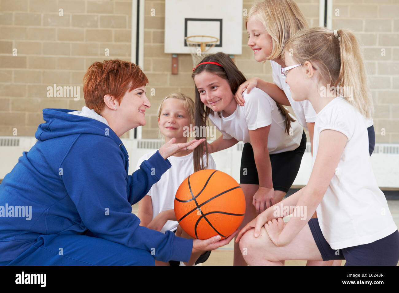 L'équipe de parler à l'enseignant de donner l'équipe de basket-ball de l'école Banque D'Images