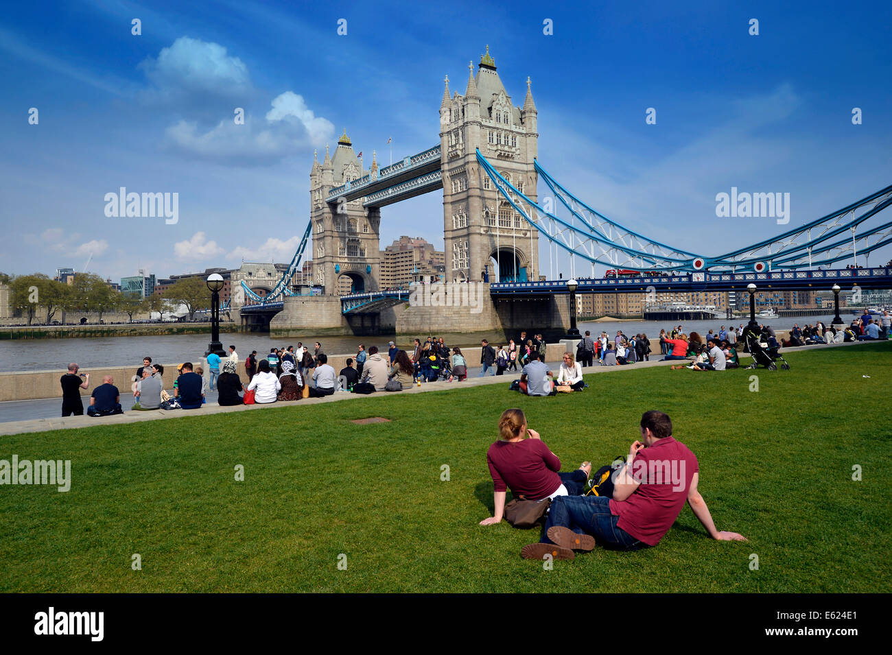 Les touristes se détendre dans les champs de potiers parc en face de Tower Bridge, Londres, Angleterre, Royaume-Uni Banque D'Images