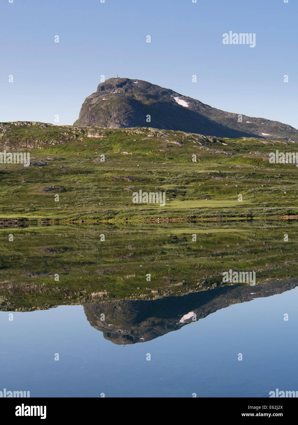 Collines et montagnes Bitihorn en Norvège Jotunheimen reflétée dans les eaux claires du lac Bygdin un matin au début de l'été Banque D'Images
