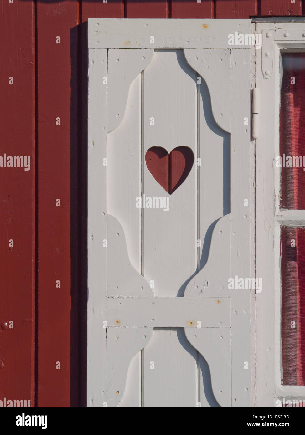 Détail de la fenêtre en bois blanc avec obturateur taillé coeur rouge sur le mur, la Norvège Banque D'Images