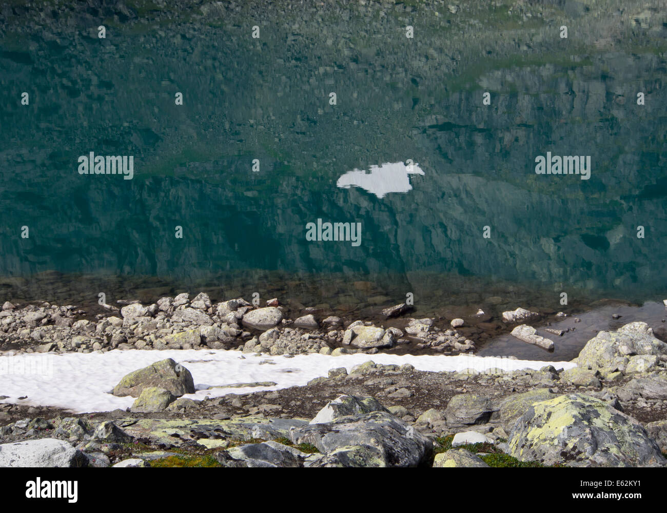 Reflet de montagne avec de la neige dans un vert glacier lake, le parc national de Jotunheimen Norvège Banque D'Images