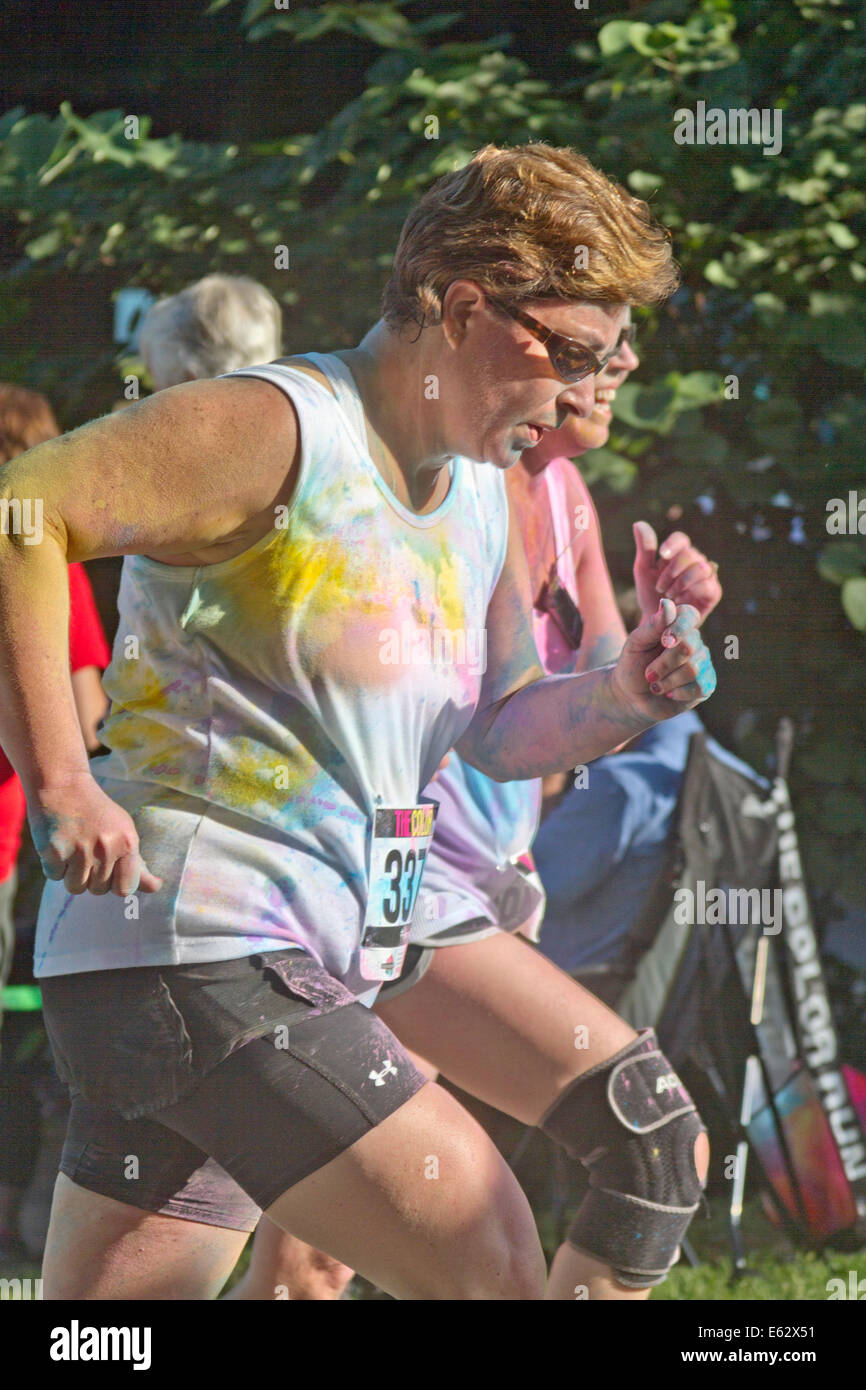 Asheville, Caroline du Nord, USA - Le 26 juillet 2014 : les coureuses éclaboussé de teintures colorées comme l'exécuter l'heureux le co d'Asheville Banque D'Images