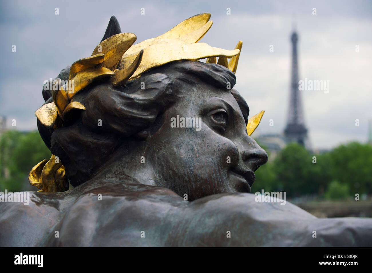 Paris France Pont Pont Alexandre III détail statue de nymphe avec couronne d'or et de la Tour Eiffel Banque D'Images