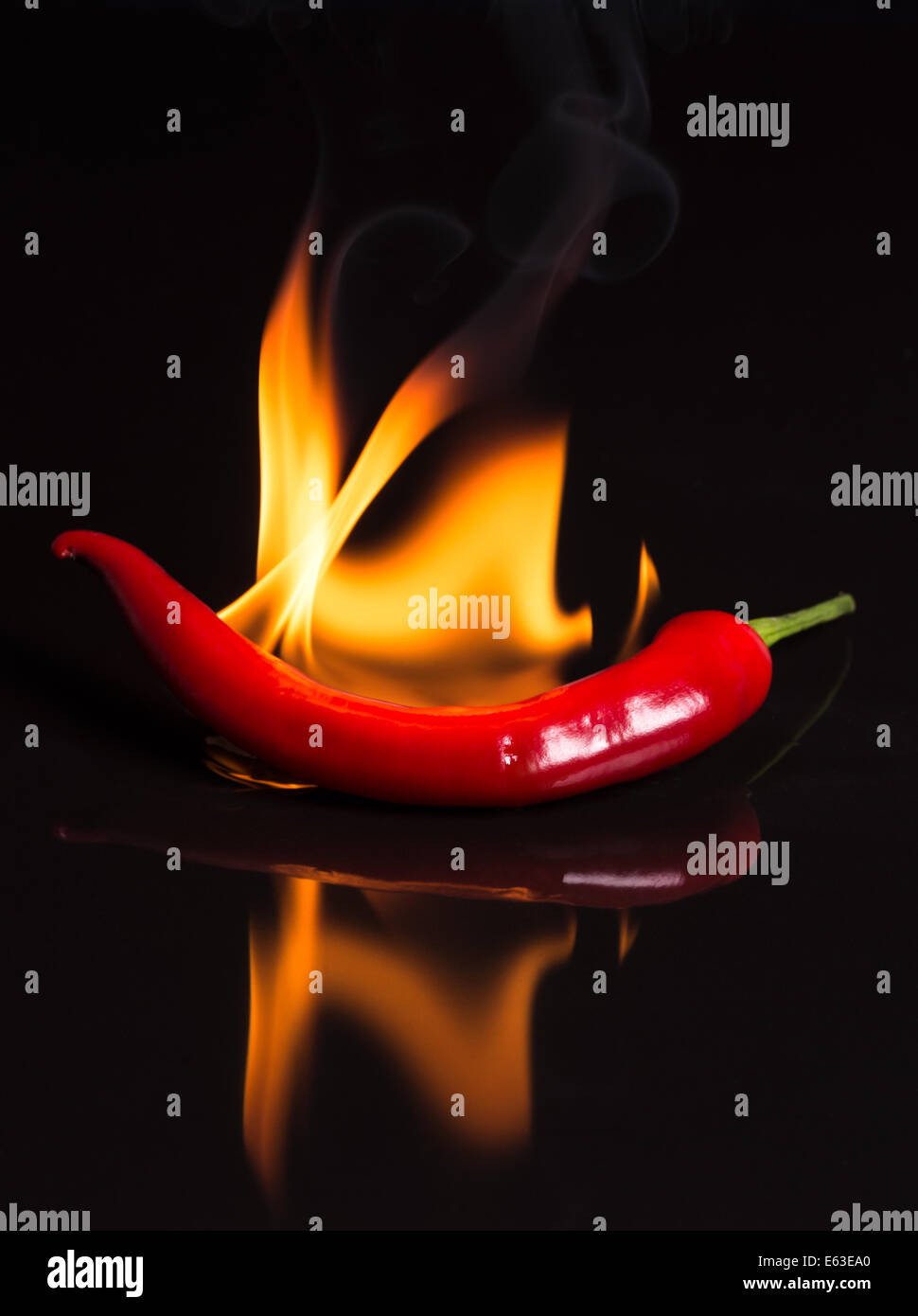 Hot Pepper - Chili et les flammes sur fond noir low key. Banque D'Images