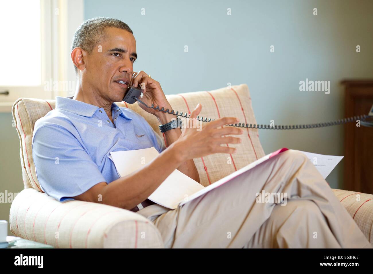 Le président américain Barack Obama parle au téléphone avec le Premier ministre Stephen Harper du Canada pour discuter de l'aggravation de la situation en Iraq le 12 août 2014 à Chilmark, Massachusetts. Banque D'Images