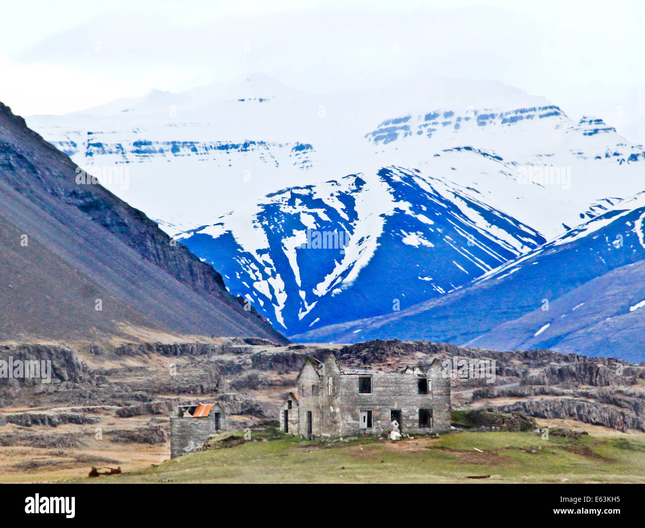 Une maison abandonnée avec un toit incliné devant se trouve dans paysage désertique avec des montagnes en toile de fond. Banque D'Images