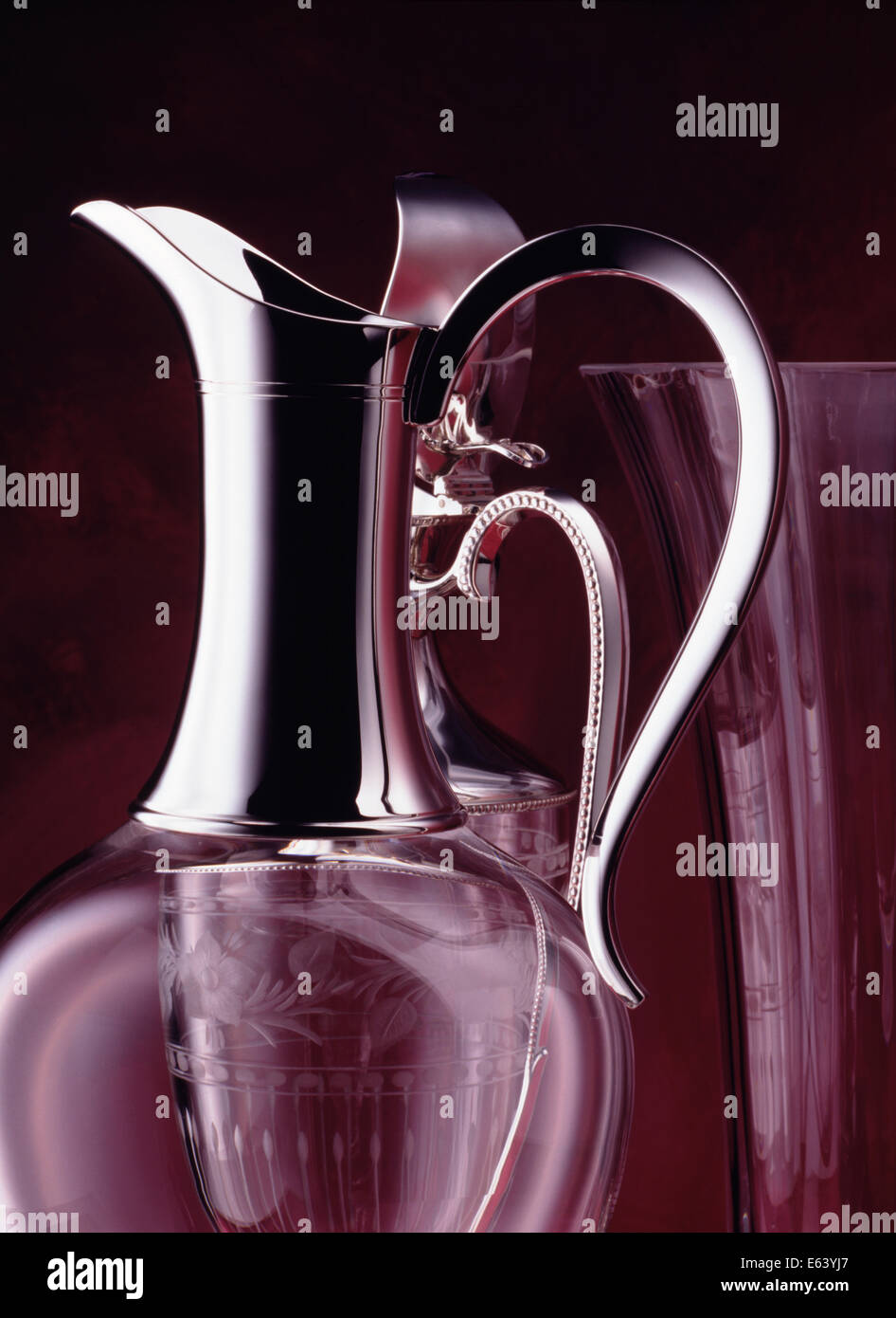 Deux d'argent et crystal Claret pichets et un vase en cristal contre un arrière-plan peint en Bourgogne. Banque D'Images