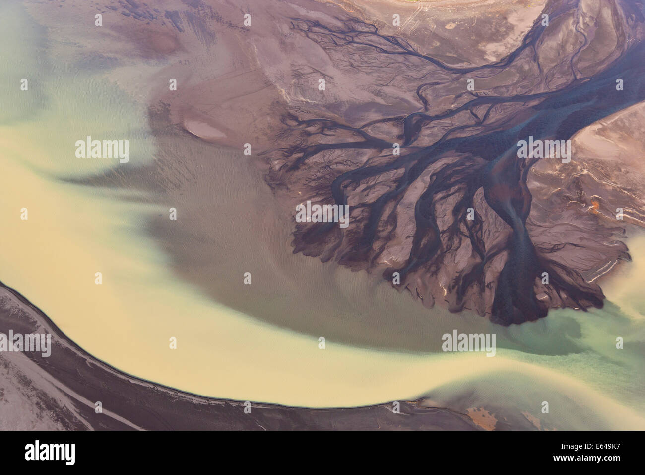Vue aérienne de l'eau de l'estuaire du fleuve coloré par la fonte des glaciers, l'Islande Banque D'Images
