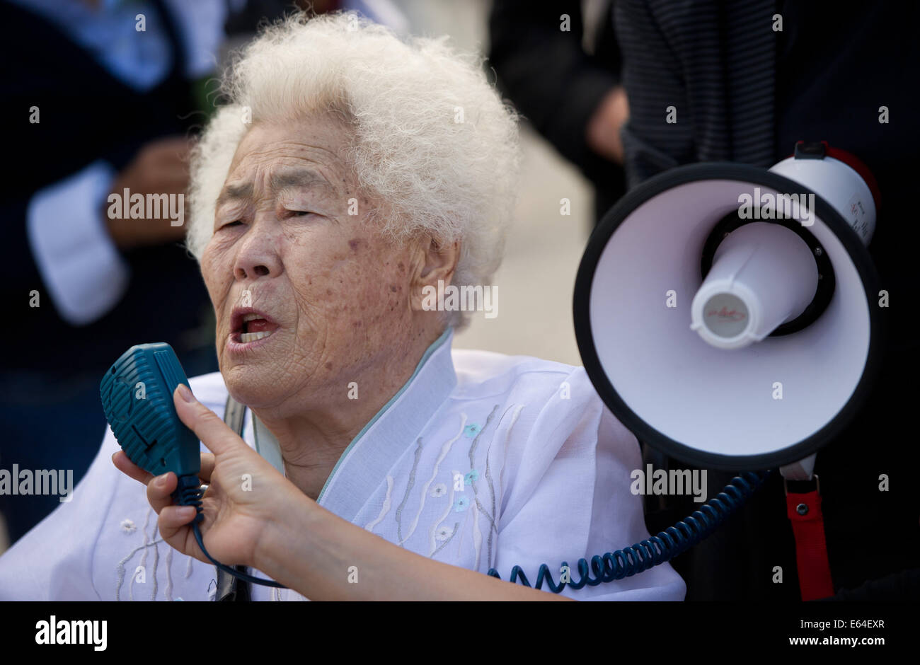 Berlin, Allemagne. 14e Août, 2014. Sud-coréen Lee Ok-Seon (R) prend la parole au rassemblement pour la soi-disant "femmes de réconfort", les femmes qui ont été enlevées et contraintes à la prostitution au Japon en vue de "confort" des soldats, à Berlin, Allemagne, 14 août 2014. Ok-Seon a été enlevé par l'armée japonaise quand elle avait 14 ans et a été autorisé à retourner dans sa patrie en 2000. Photo : DANIEL NAUPOLD/dpa/Alamy Live News Banque D'Images