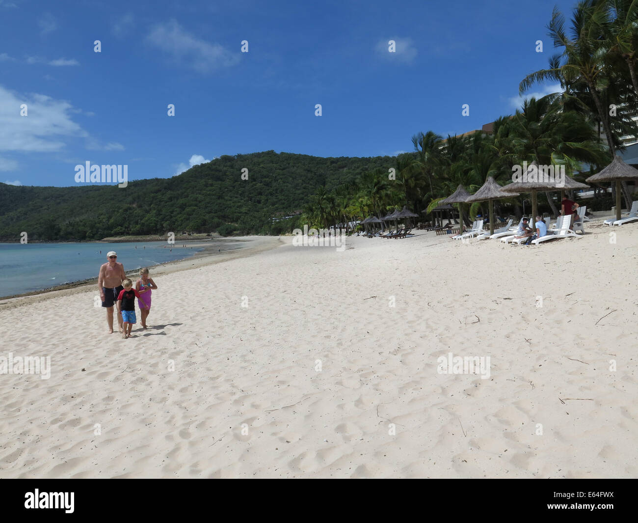 Jeune famille à marcher le long de la plage Catseye sur Hamilton Island dans les Whitsunday Islands, de l'Australie. Banque D'Images