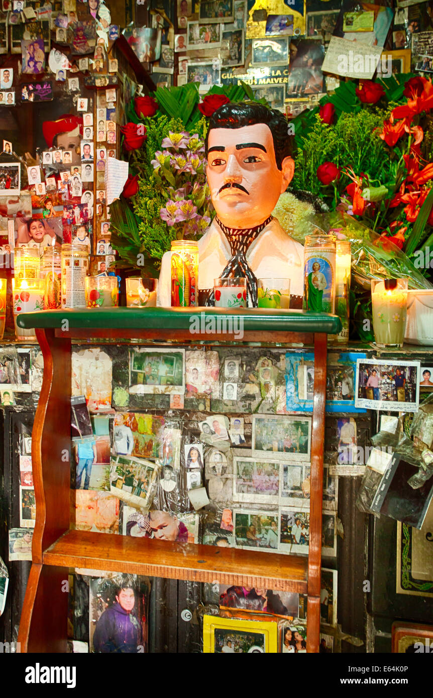 Des photographies, des messages de remerciements et de fleurs entourent un sanctuaire dédié à Malverde, le saint patron de la commerce illicite des drogues. Banque D'Images