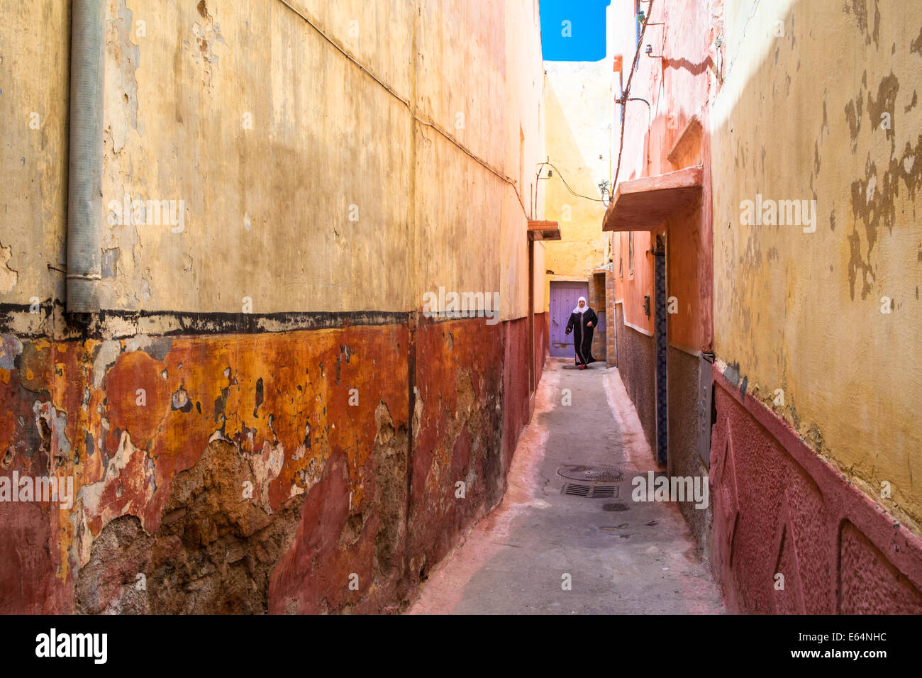 Femme musulmane arabe, portant un foulard et d'une djellaba noire, dans une ruelle pittoresque de la médina de Salé, près de Rabat, Maroc. Banque D'Images