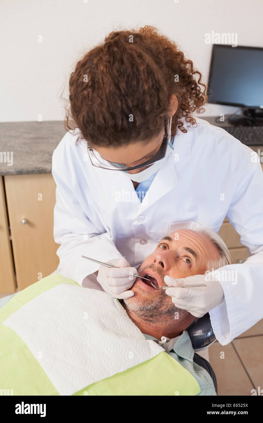 L'examen d'un dentiste dents patients dans les dentistes président Banque D'Images