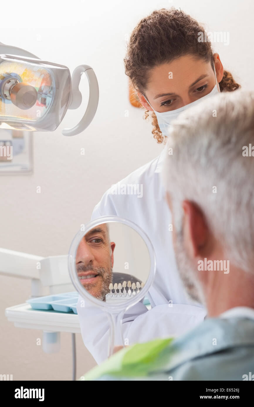 Patient d'admirer son nouveau sourire dans le miroir Banque D'Images