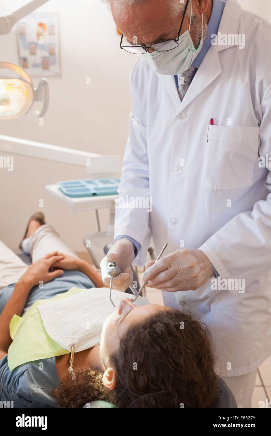 L'examen d'un dentiste dents patients dans les dentistes président Banque D'Images