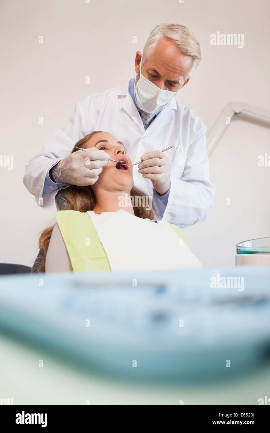 L'examen d'un dentiste dents patients dans les dentistes président Banque D'Images