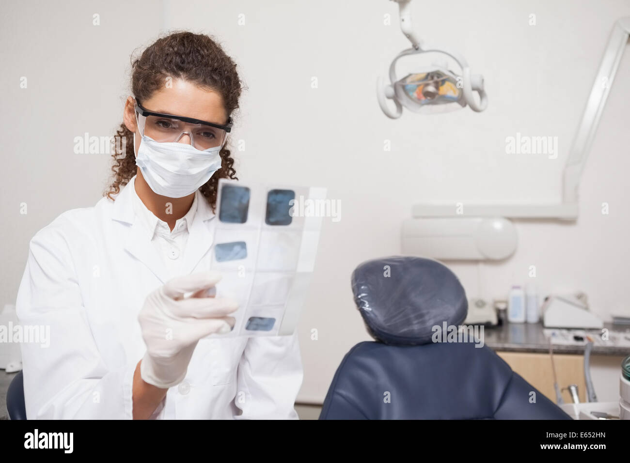 Dentiste l'examen de radiographies wearing surgical mask Banque D'Images