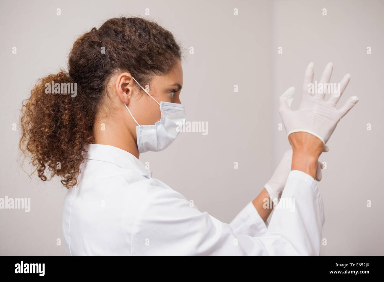 Dentiste de mettre des gants chirurgicaux Banque D'Images