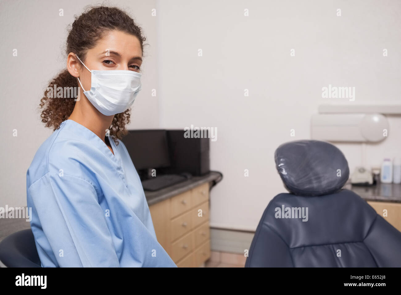 Dentiste en masque chirurgical looking at camera Banque D'Images