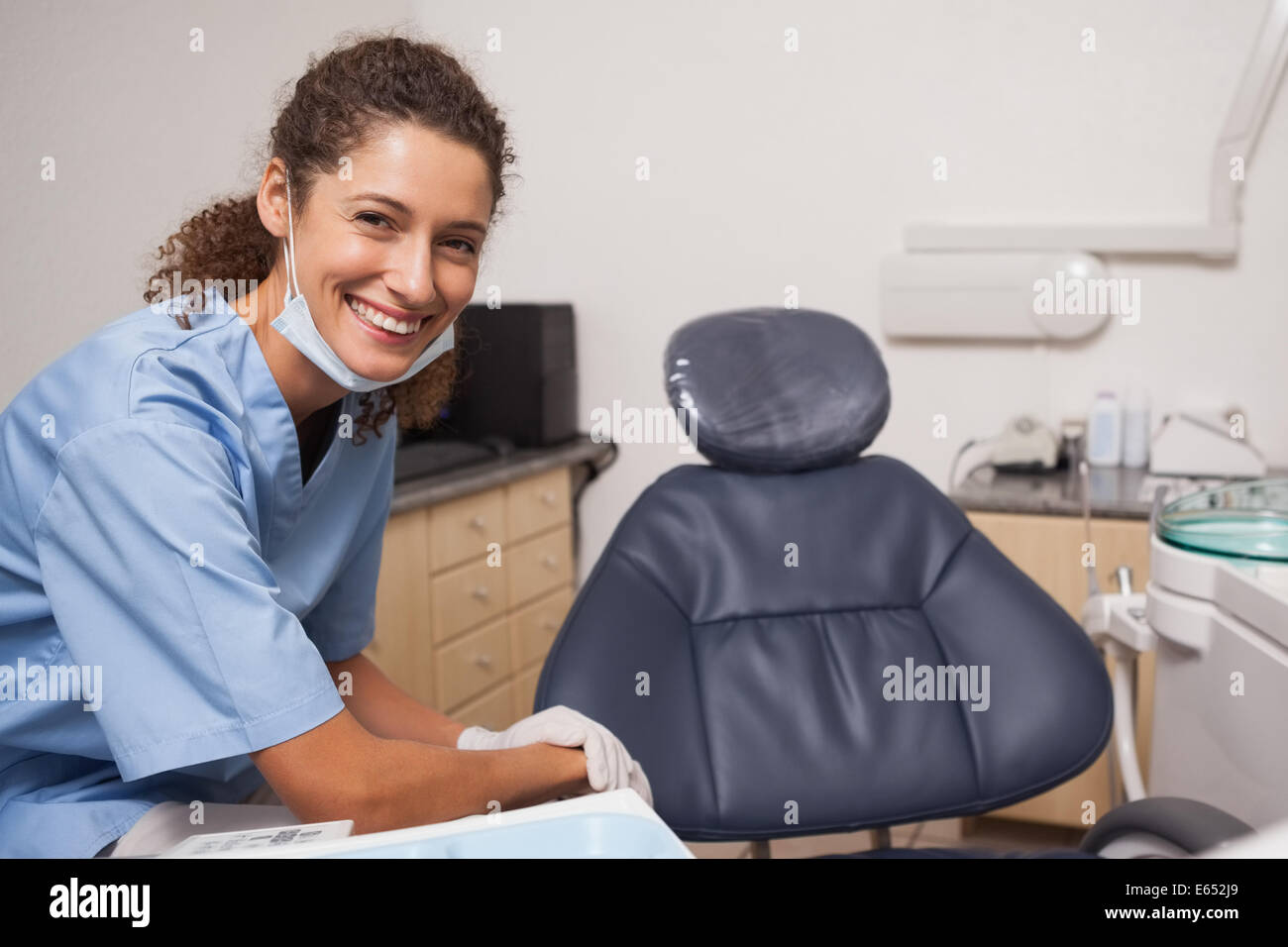 Dentiste en masque chirurgical smiling at camera Banque D'Images