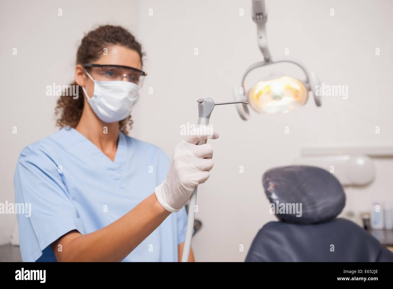 Dentiste en masque et lunettes de protection holding drill Banque D'Images