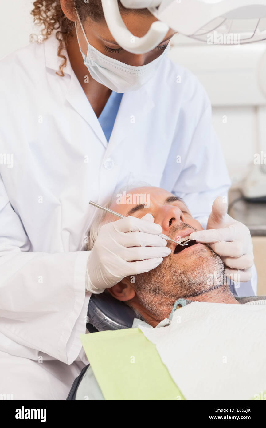 L'examen d'un dentiste dents patients dans les dentistes président Banque D'Images