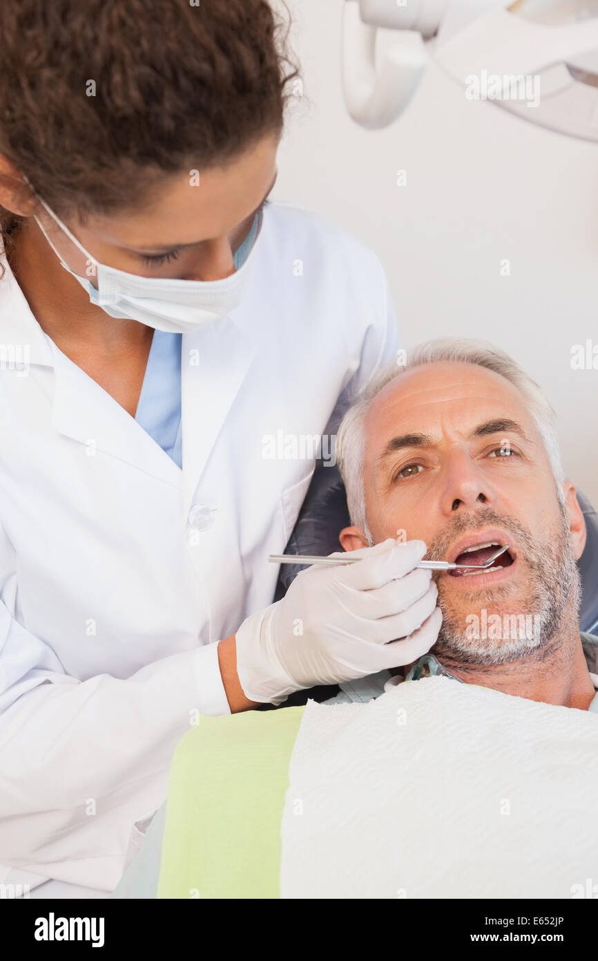 L'examen d'un dentiste dents patients dans les dentistes président Banque D'Images