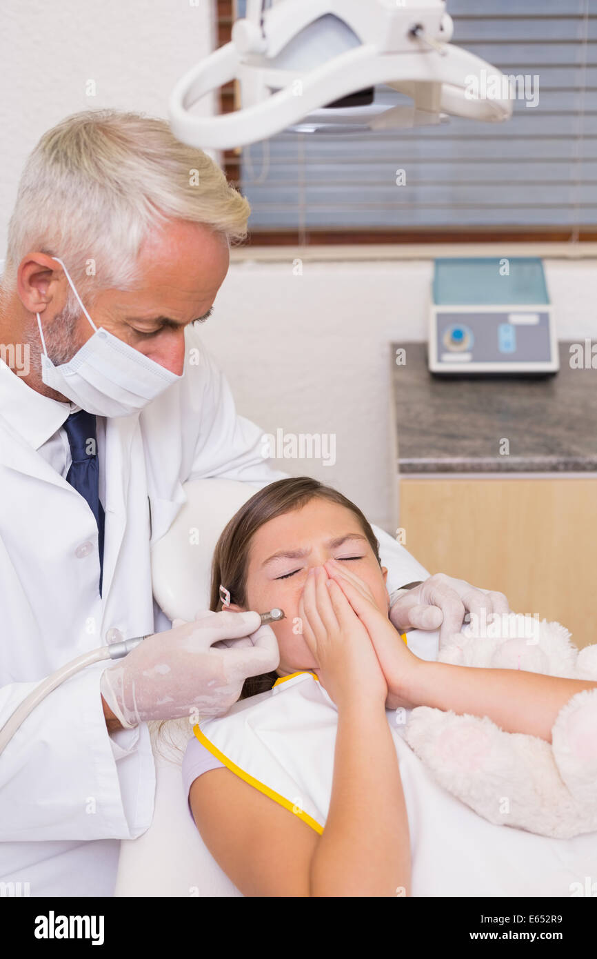 Pédodontiste essayant de voir les dents de patients l'éternuement Banque D'Images