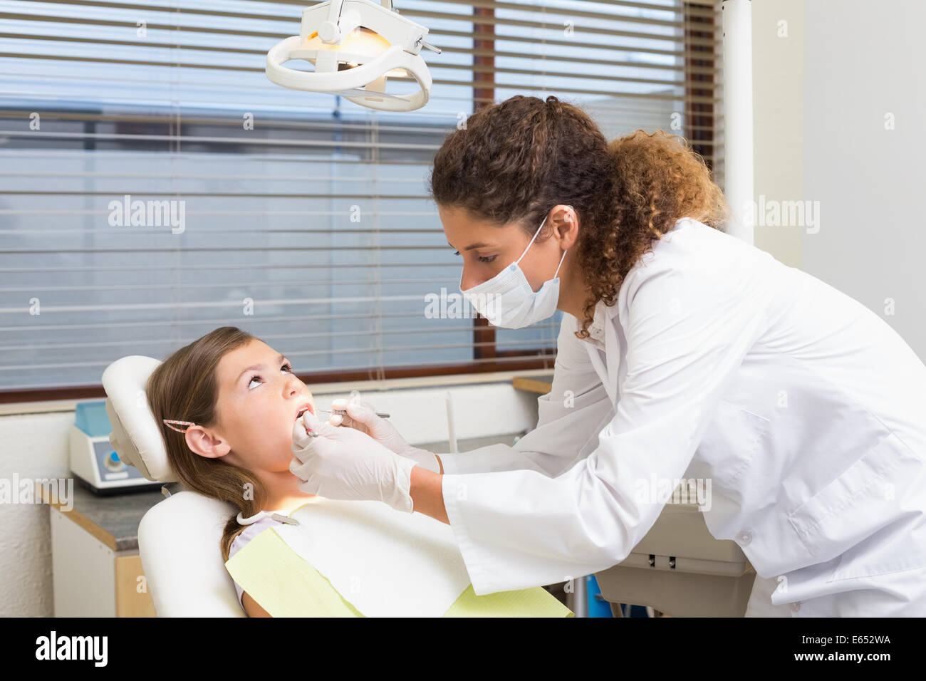L'examen d'un dentiste pédiatrique patients dents sur les dentistes président Banque D'Images